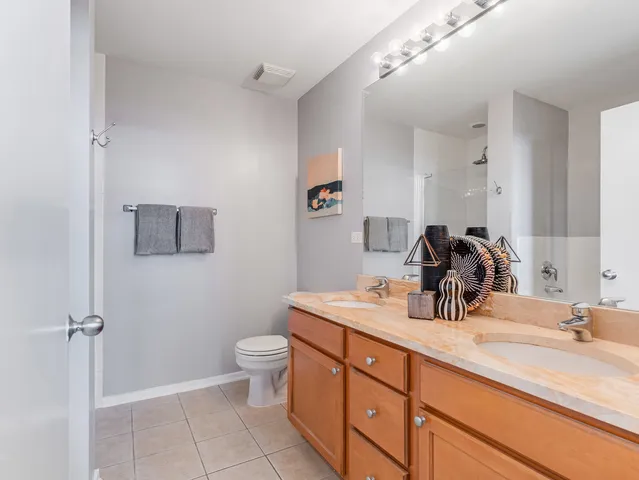 a bathroom with a double vanity sink toilet and mirror