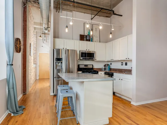 a kitchen with a refrigerator a sink and cabinets