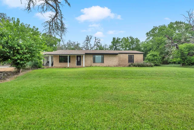 a house with a big yard and large trees