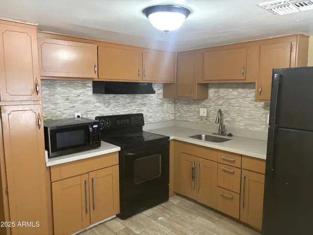 a kitchen with a sink stove and refrigerator