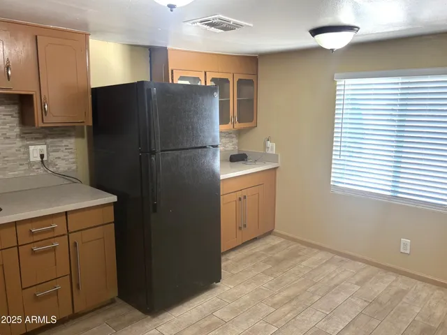 a kitchen with a refrigerator sink and cabinets