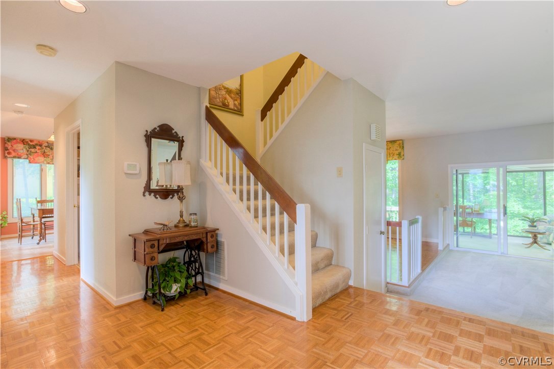 Foyer with parquet floor opens to the living space