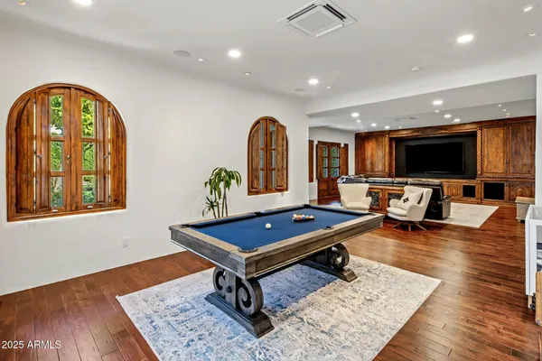 a bedroom with a bed a fireplace and a flat screen tv