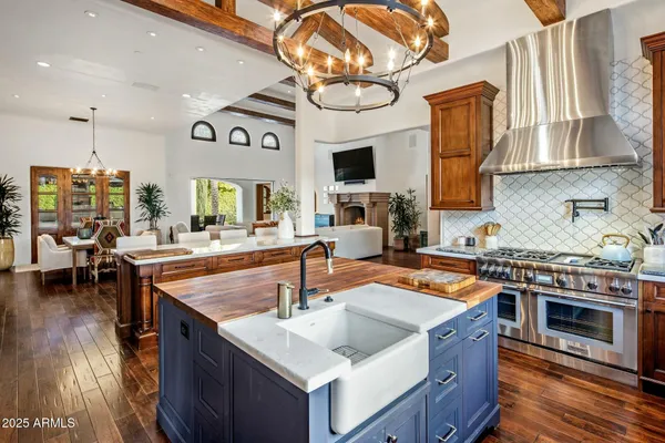 a kitchen with stainless steel appliances granite countertop a sink a stove and a wooden floors