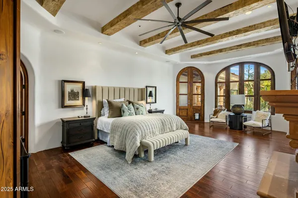 a spacious bedroom with a bed a couch and a chandelier