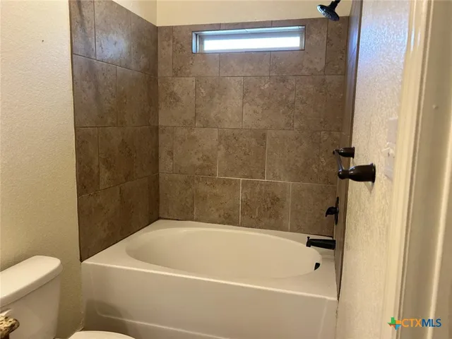 a white bath tub sitting next to a white toilet and sink