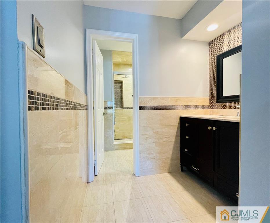 701 Timber Oaks Road Edison, NJ 08820 - Photo 15 of 23 a bathroom with a granite countertop sink a mirror and a shower
