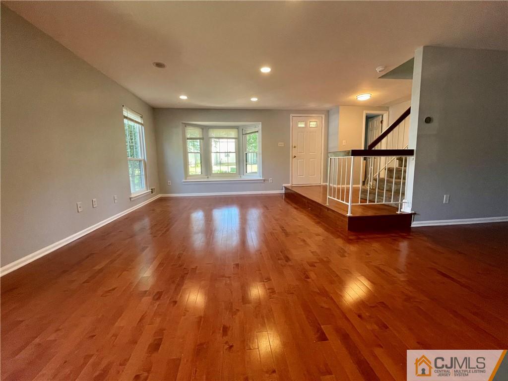 701 Timber Oaks Road Edison, NJ 08820 - Photo 8 of 23 an empty room with wooden floor and windows