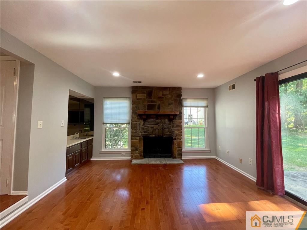 701 Timber Oaks Road Edison, NJ 08820 - Photo 10 of 23 an empty room with wooden floor fireplace and windows