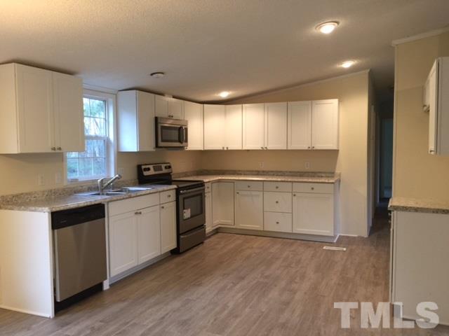10835 Smith Road Middlesex, NC 27557 - Photo 3 of 13 a kitchen with granite countertop a sink cabinets and stainless steel appliances