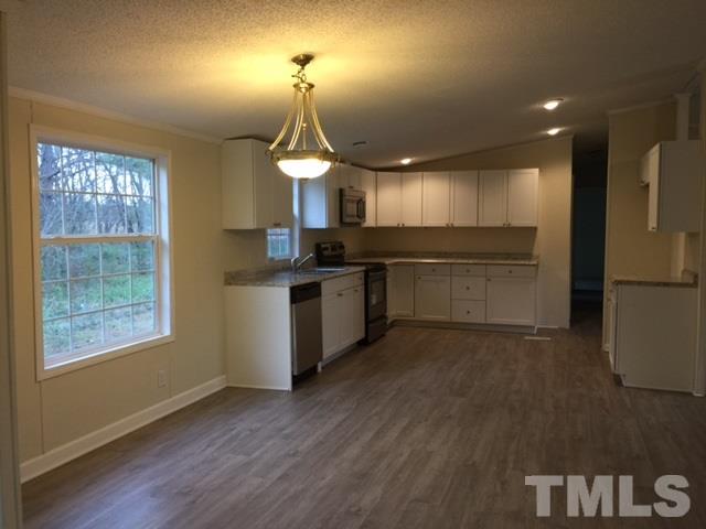 10835 Smith Road Middlesex, NC 27557 - Photo 4 of 13 a kitchen with stainless steel appliances granite countertop a stove a sink and a refrigerator
