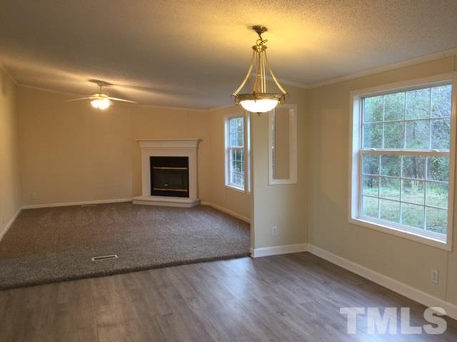 10835 Smith Road Middlesex, NC 27557 - Photo 5 of 13 an empty room with a chandelier fan and a window