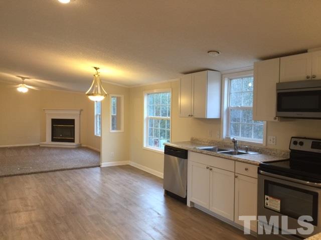 10835 Smith Road Middlesex, NC 27557 - Photo 6 of 13 a kitchen with stainless steel appliances granite countertop a stove a sink and a refrigerator
