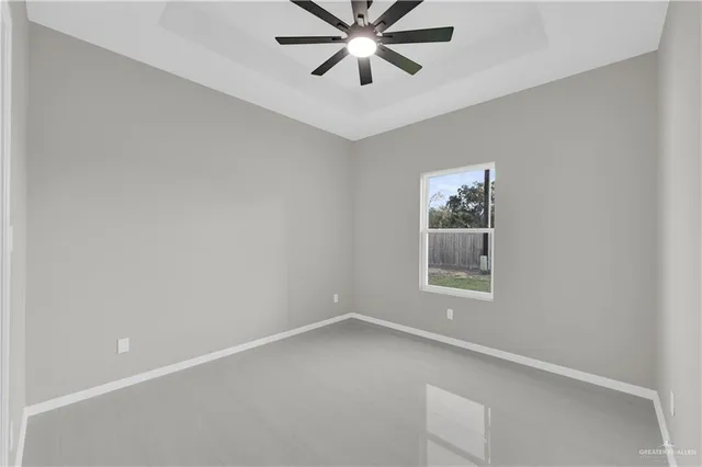 an empty room with a window and a fan