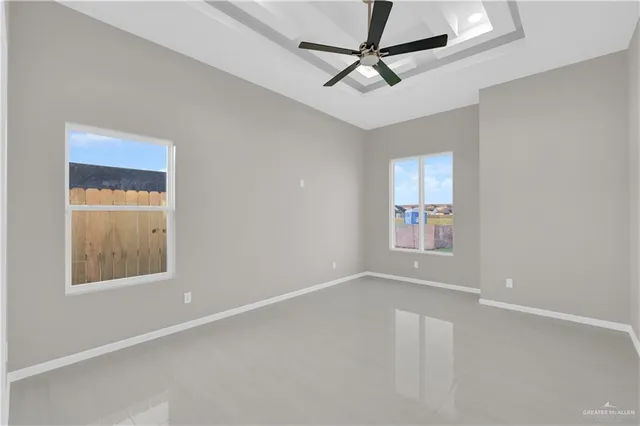 an empty room with a window and a fan
