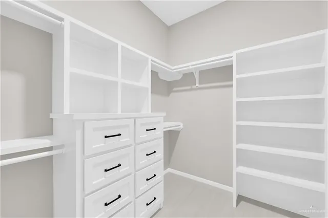 a view of walk in closet with empty racks