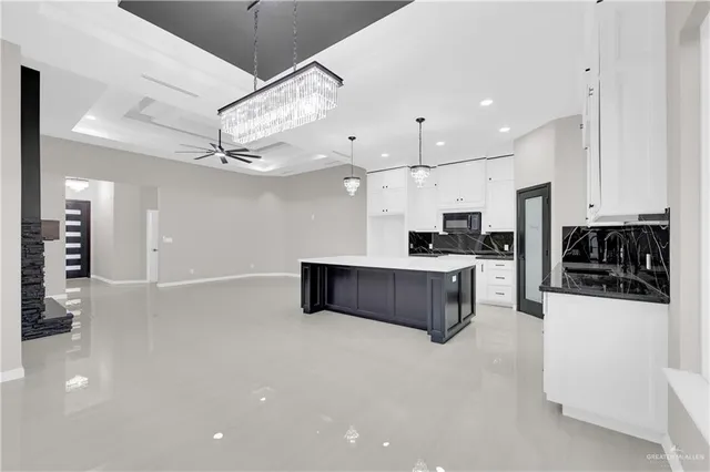 a large white kitchen with a refrigerator a stove a sink dishwasher and a stove with wooden floor