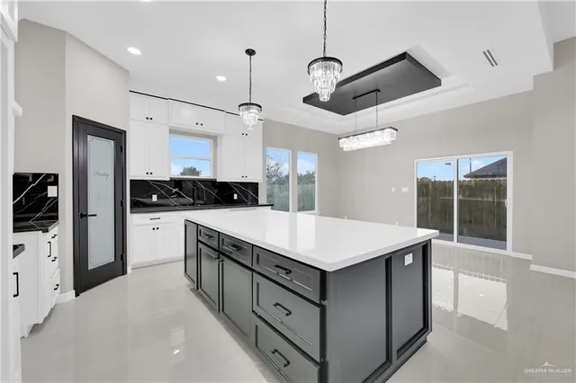 a kitchen with a stove a refrigerator a sink and chairs