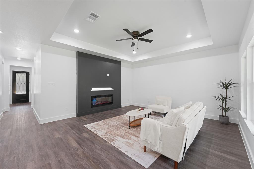 122 East Beachwood Loop Trinidad, TX 75163 - Photo 8 of 35 Living area featuring wood-finish flooring, a tray ceiling with a ceiling fan, recessed lighting, and a modern linear fireplace set into a dark accent wall