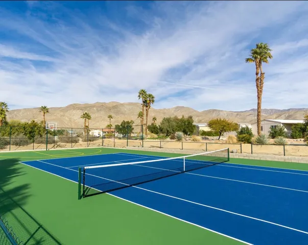 a view of a tennis court with chairs