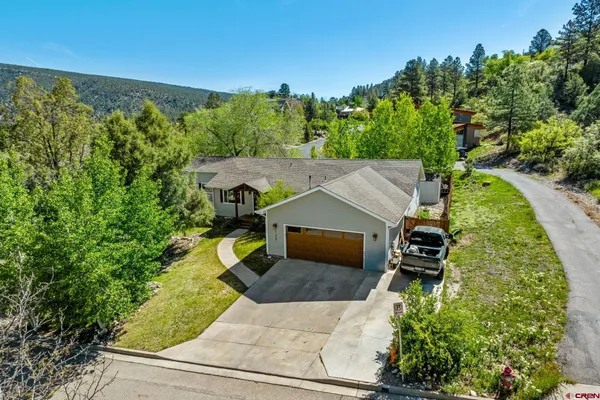 an aerial view of a house with swimming pool and garden