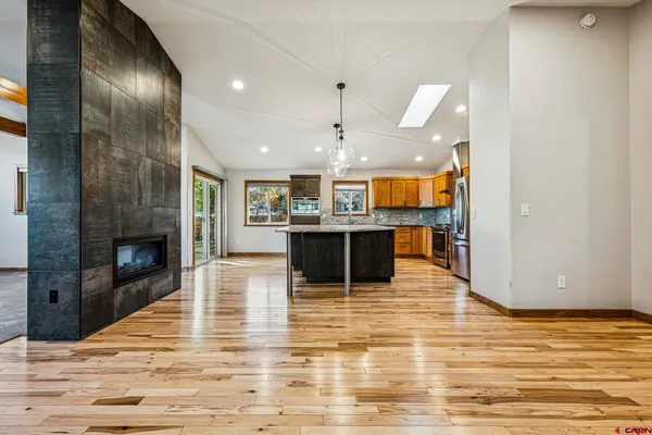 a kitchen with wooden floor and large windows