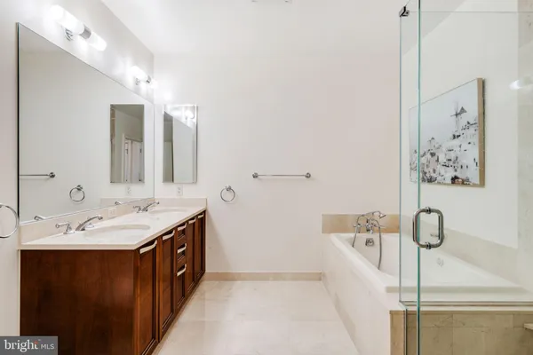 a spacious bathroom with a tub sink and mirror