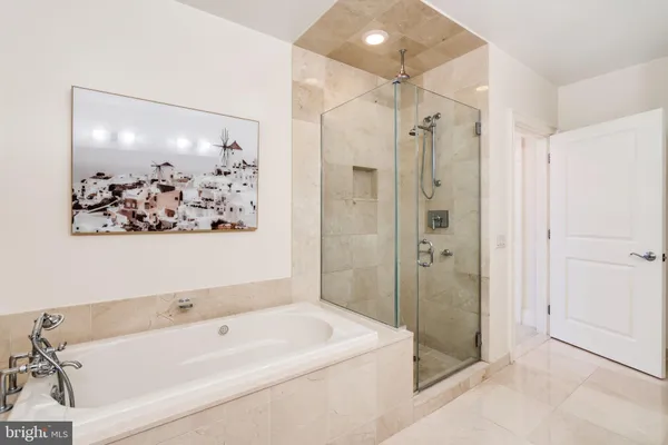 a bathroom with a tub a sink and glass door