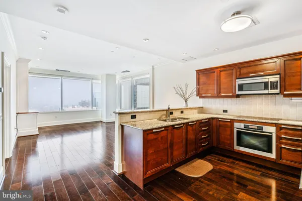 a kitchen with stainless steel appliances granite countertop a stove and a wooden cabinets