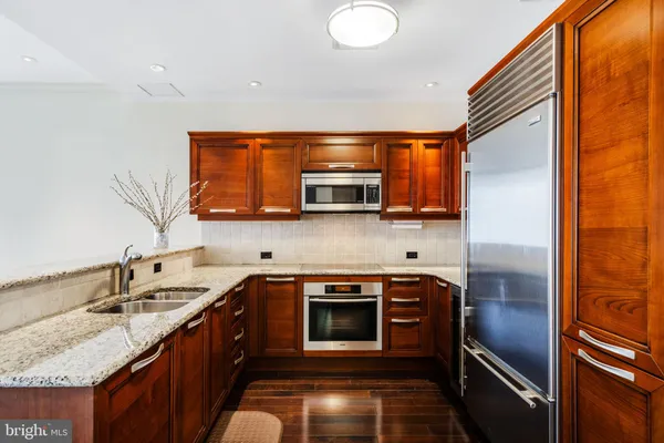 a kitchen with stainless steel appliances granite countertop a sink and a microwave