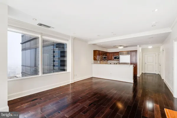 a view of a big room with wooden floor and windows