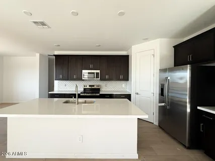 a kitchen with stainless steel appliances a refrigerator a stove a sink and a refrigerator
