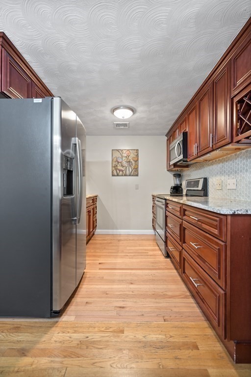 29 Karen Road Wakefield, MA 01880 - Photo 14 of 42 a large kitchen with stainless steel appliances granite countertop a refrigerator a stove and a sink with cabinets