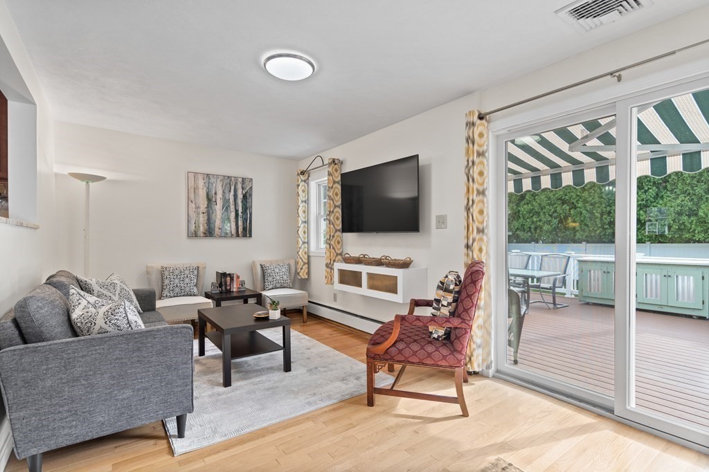 29 Karen Road Wakefield, MA 01880 - Photo 16 of 42 a living room with furniture a flat screen tv and a floor to ceiling window