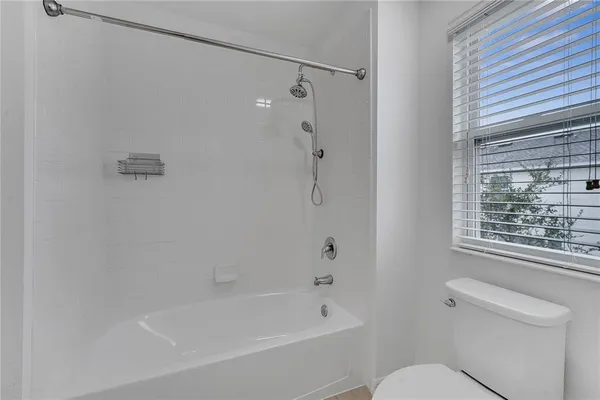 a view of empty room with wooden floor and ceiling fan
