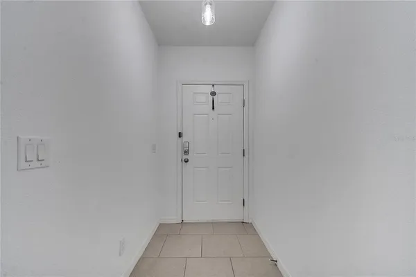 a view of an empty room and kitchen