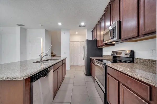 a view of kitchen with kitchen island white cabinets and stainless steel appliances