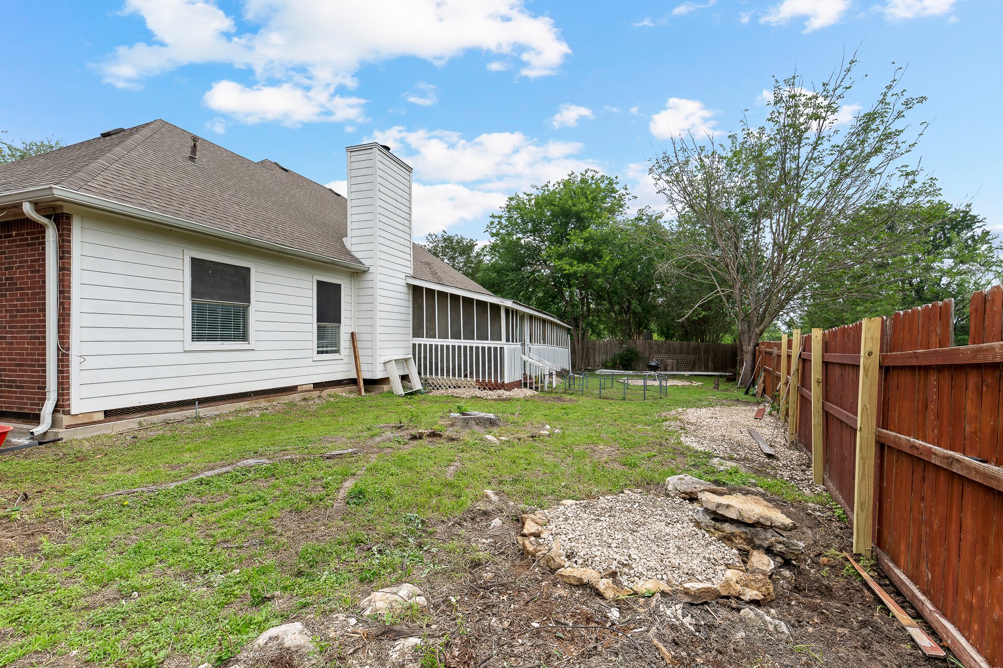 11737 Rydalwater Lane Austin, TX 78754 - Photo 39 of 40 Expansive backyard featuring a partial privacy fence, a screened porch, and a combination of brick and siding exterior