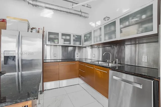 a kitchen with stainless steel appliances granite countertop a refrigerator and a sink