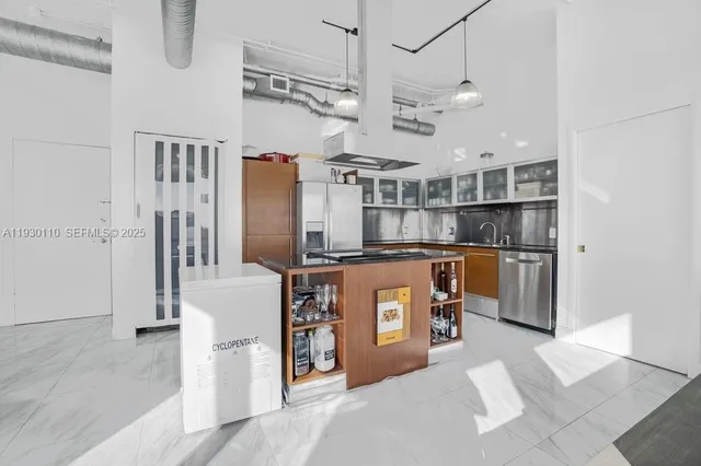 a kitchen with stainless steel appliances kitchen island granite countertop a refrigerator and a stove