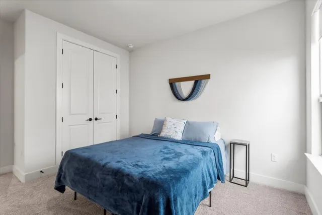 a bedroom with a bed and a painting on the wall