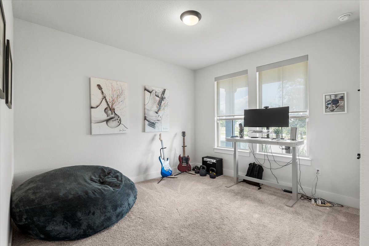 8501 Hillock Terrace Austin, TX 78744 - Photo 27 of 32 a room with a couch and a flat screen tv