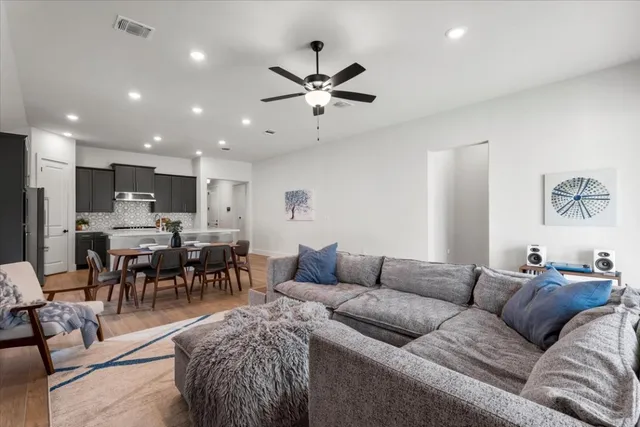a living room kitchen with a dining table a chandelier and a dining table