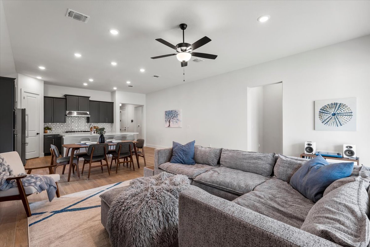 8501 Hillock Terrace Austin, TX 78744 - Photo 6 of 32 a living room kitchen with a dining table a chandelier and a dining table