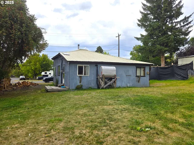 a view of a house with a patio and a yard