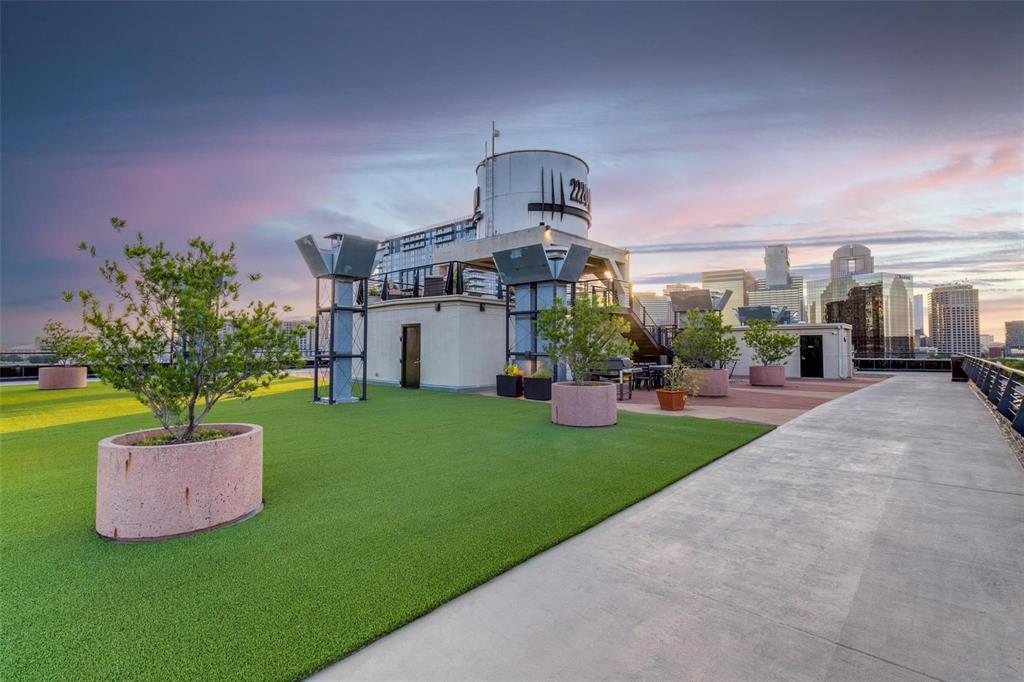 2220 Canton Street, Unit 101 Dallas, TX 75201 - Photo 16 of 20 Rooftop amenity space featuring artificial turf, concrete pathways, and multiple planter boxes with mature trees