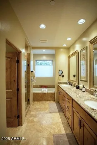 a bedroom with a bed wooden floor and couch