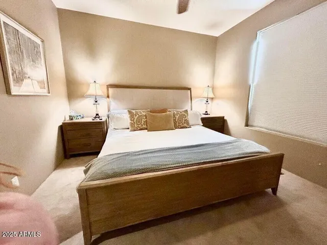 a bedroom with a bed mirror and a wall painting