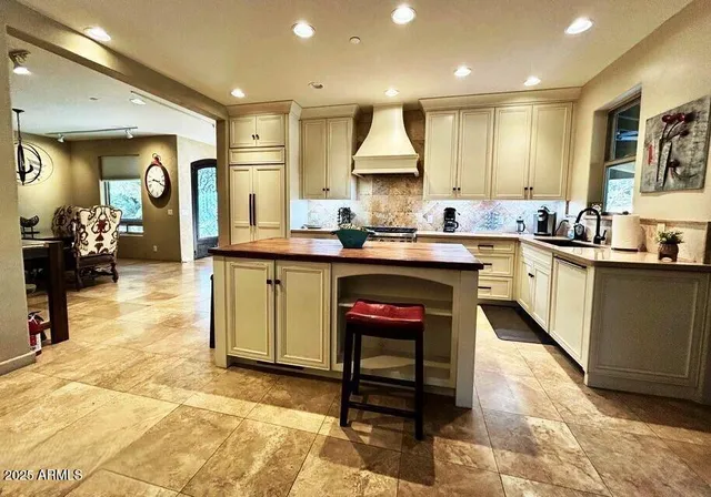 a kitchen with stainless steel appliances a stove a sink and white cabinets