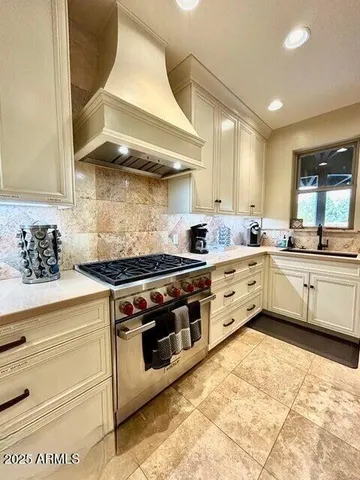 a kitchen with stainless steel appliances granite countertop a stove and white cabinets